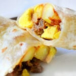 breakfast burrito cut in half on white plate