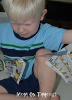 little boy shredding newspaper