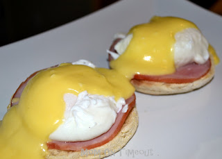 eggs benedict with hollandaise sauce on white plate