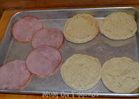 canadian bacon and english muffins on baking sheet