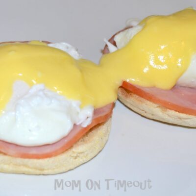 eggs benedict with hollandaise sauce on white plate