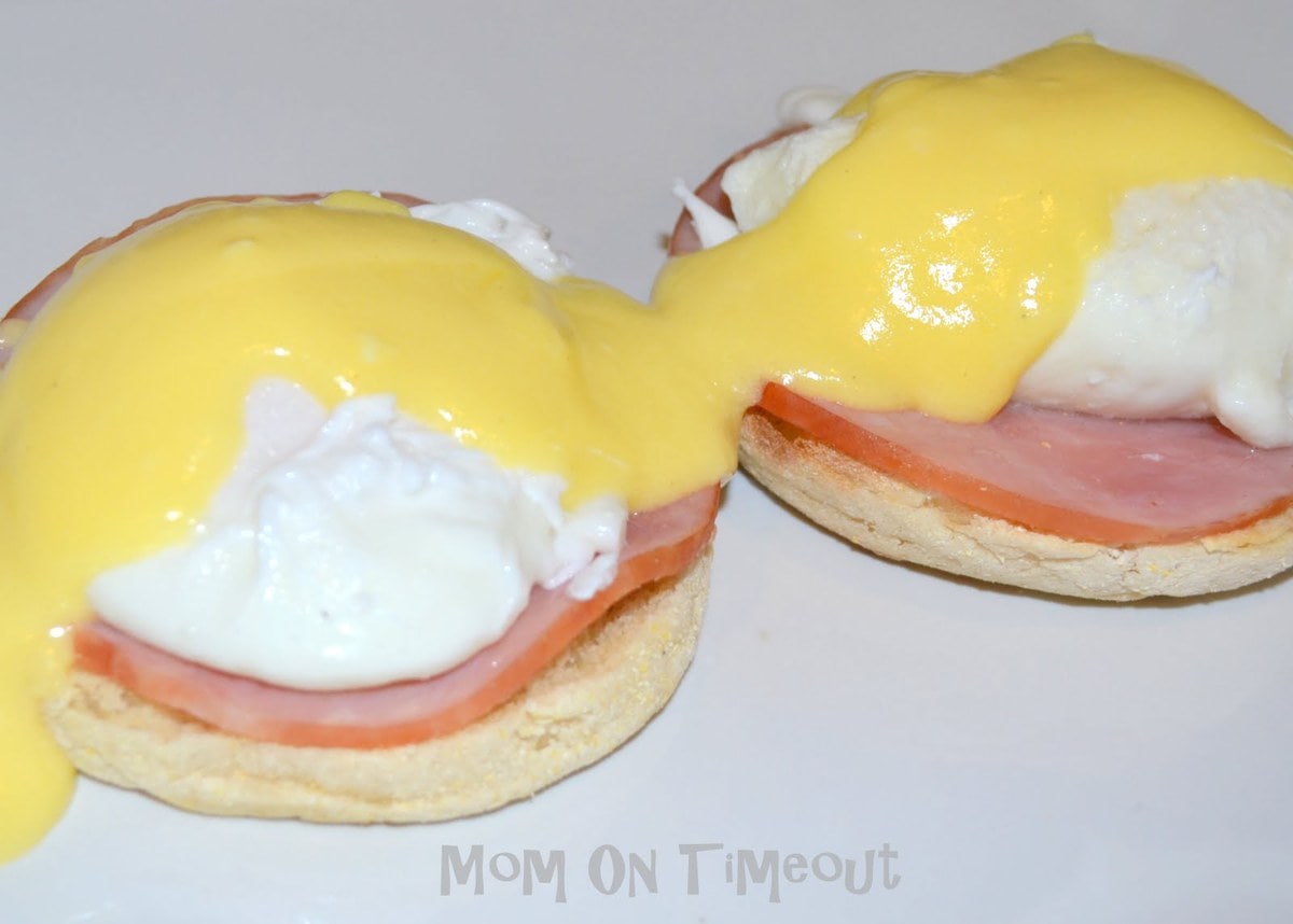 eggs benedict with hollandaise sauce on white plate