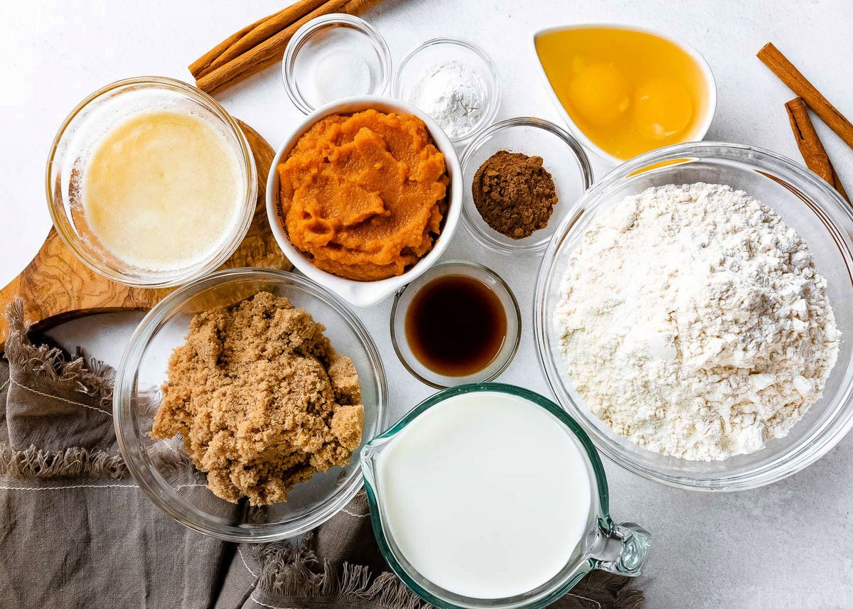 pumpkin pancakes ingredients measured into small bowls on white surface