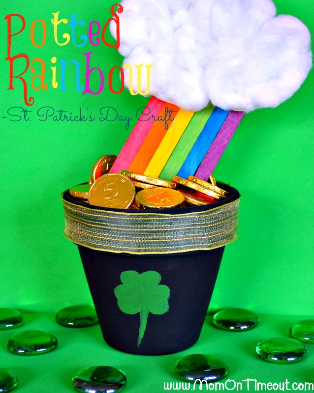A pot of chocolate coins at the end of a craft stick rainbow with a big fluffy cloud at the top.