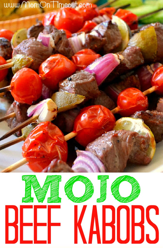 mojo beef kabobs on skewers on white plate with text overlay