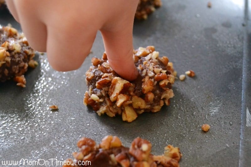 Get ready to impress with this easy Turtle Thumbprint Cookies recipe! Decadent chocolate cookies rolled in pecans and filled with soft caramel make any cookie tray look extra special! Perfect for the holidays! 