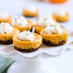 mini pumpkin cheesecake on white cake stand with title