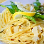 plate of lemon spaghetti garnished with parmesan lemon and basil square