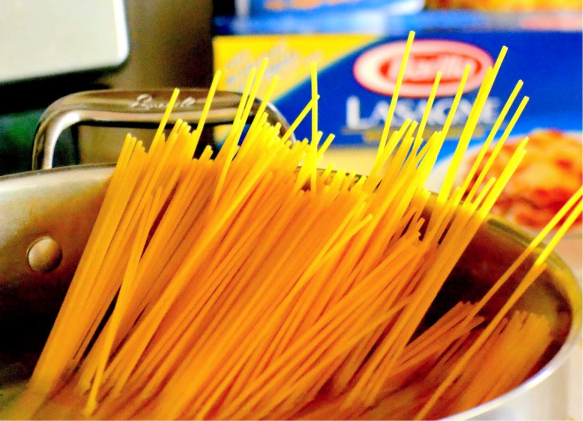 spaghetti nudler i stor gryde med vand endnu ikke kogt