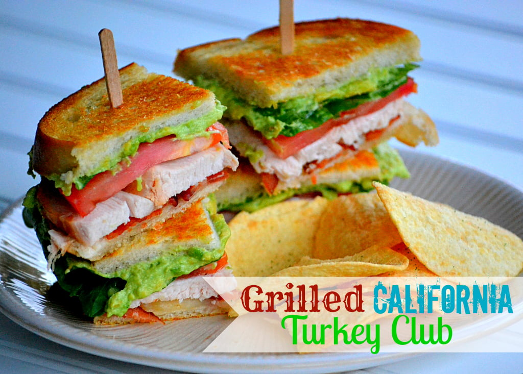 turkey club sandwich with avocado and bacon on small lunch plate