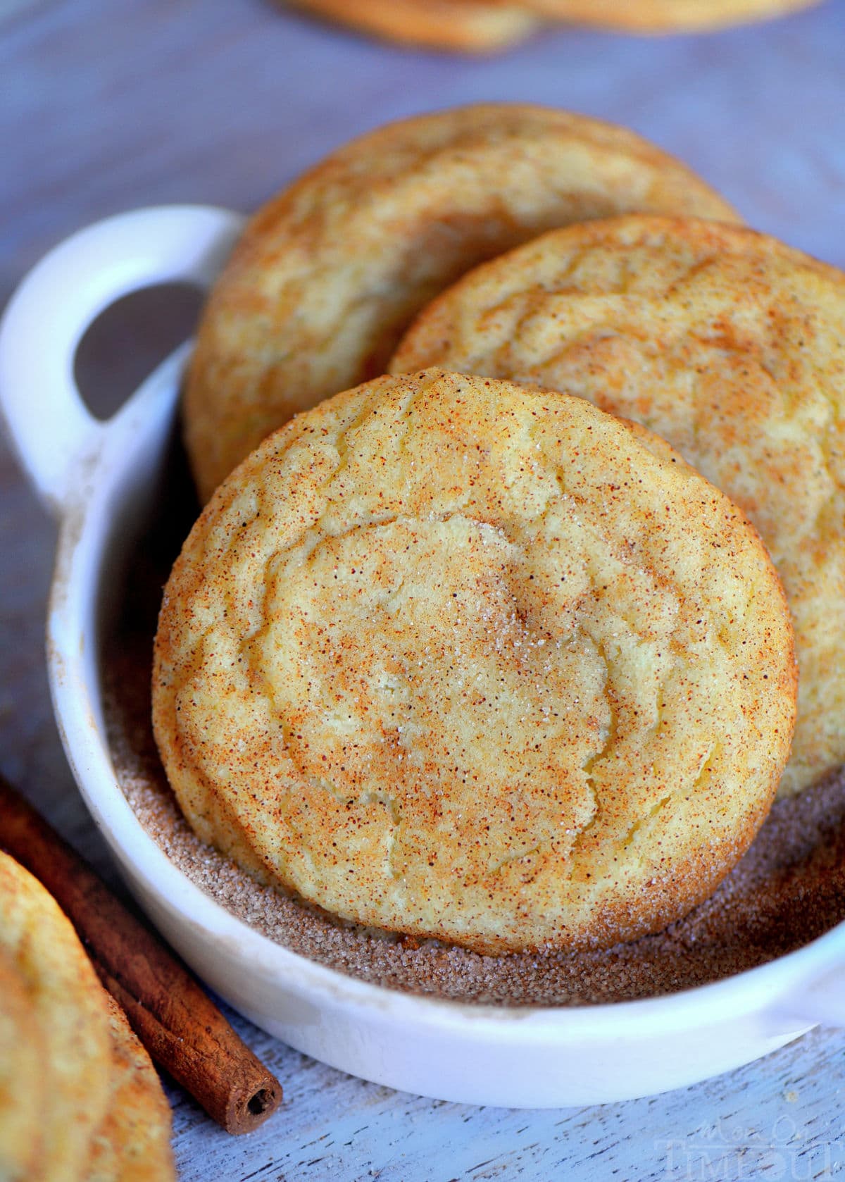 snickerdoodle cookies in cinnamon sugar mixture in small white bowl