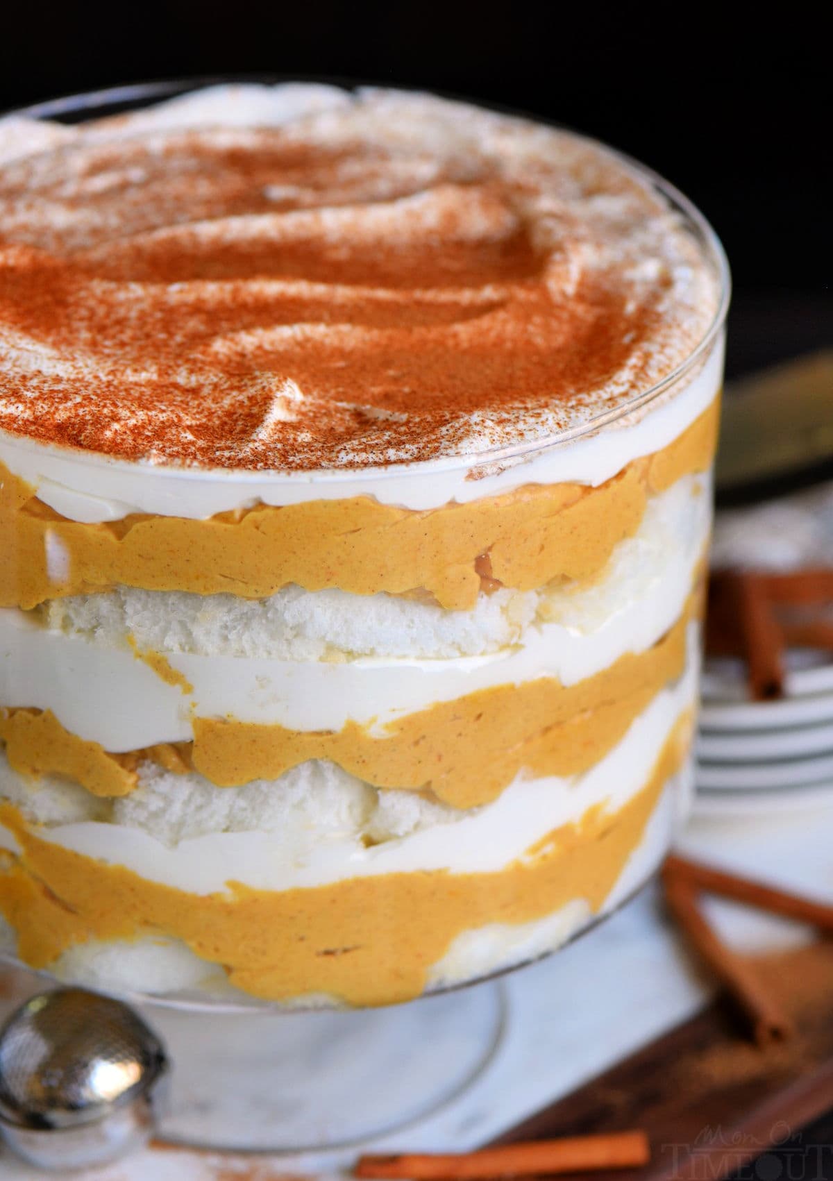 close up view of pumpkin cheesecake trifle in clear glass trifle dish topped with pumpkin pie spice.