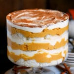 pretty pumpkin trifle in trifle dish with layers of pumpkin cheesecake, whipped cream and angel food cake.