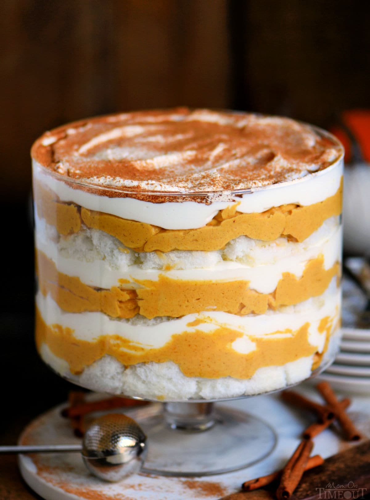 pretty pumpkin trifle in trifle dish with layers of pumpkin cheesecake, whipped cream and angel food cake.