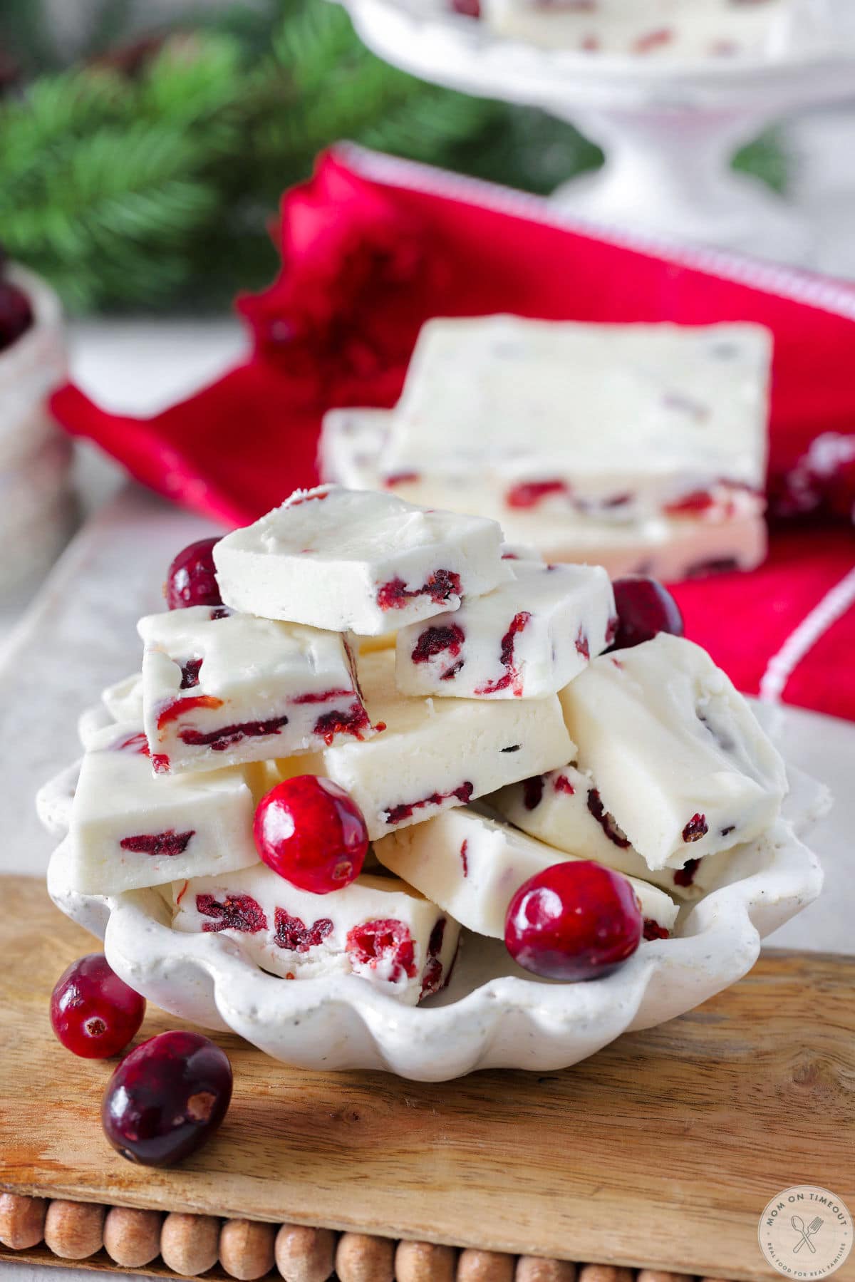 Small white bowl filled with small squares of cranberry white chocolate fudge.