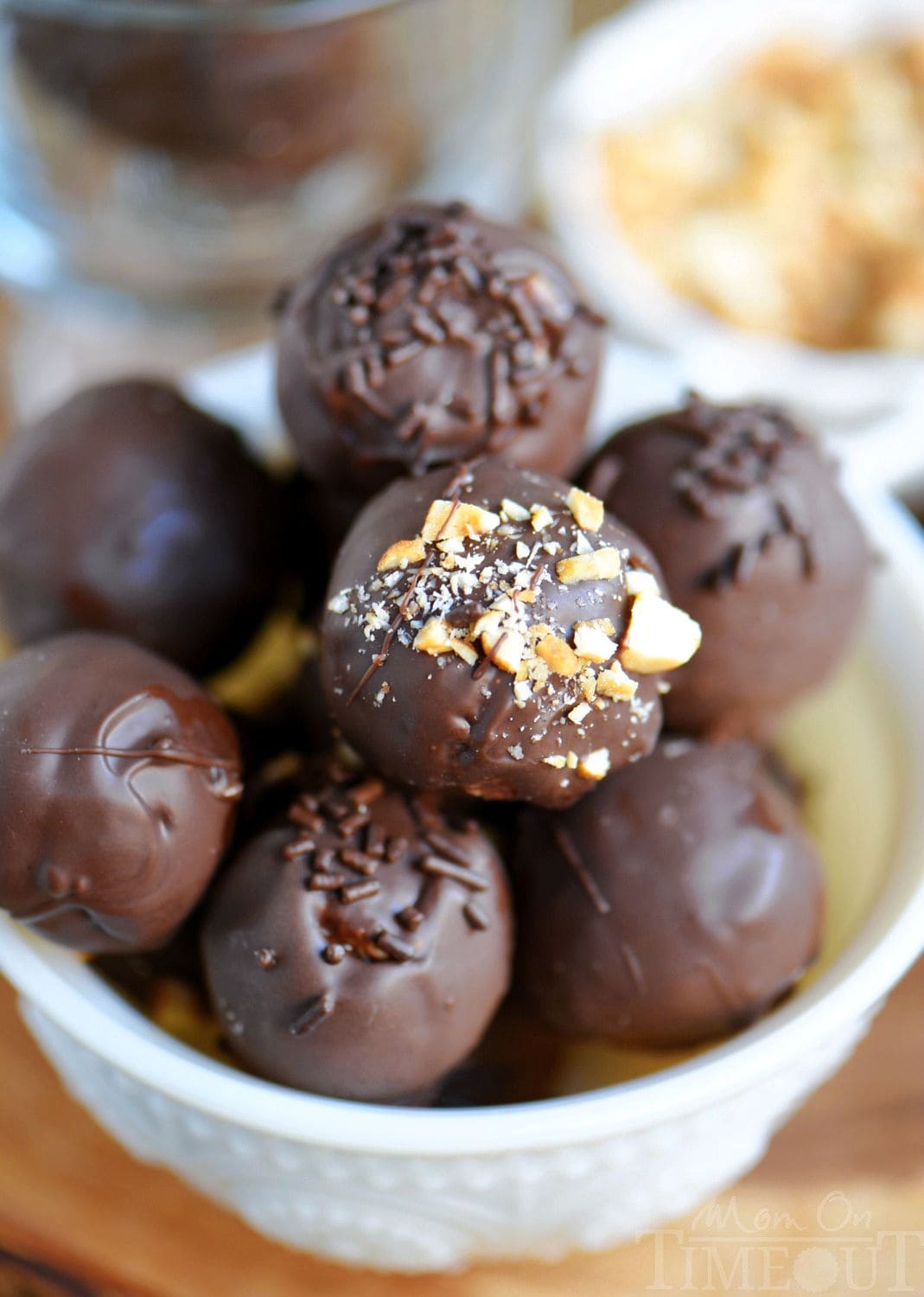 whole chocolate peanut butter balls in a white glass bowl ready to be enjoyed.