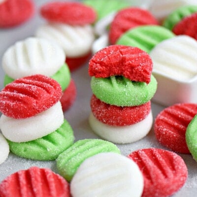 red white and green christmas peppermint patties stacked and scattered on a parchment paper.