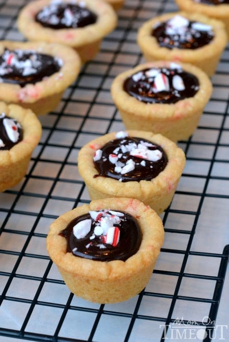 Dark Chocolate Peppermint Sugar Cookie Cups filled with chocolate ganache and topped with Candy Cane Hershey's Kisses. | MomOnTimeout.com #christmas #recipe