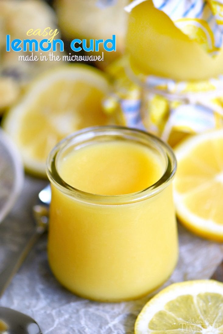 lemon curd in a glass jar with sliced lemons around it