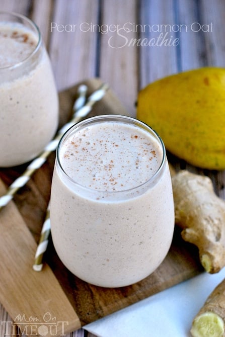 pear ginger smoothie in short glass with straws on the side and fresh pear and ginger next to it