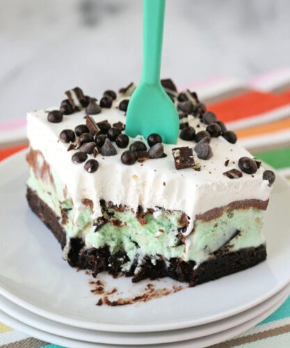 ice cream cake square on white plate with colorful striped napkin underneath