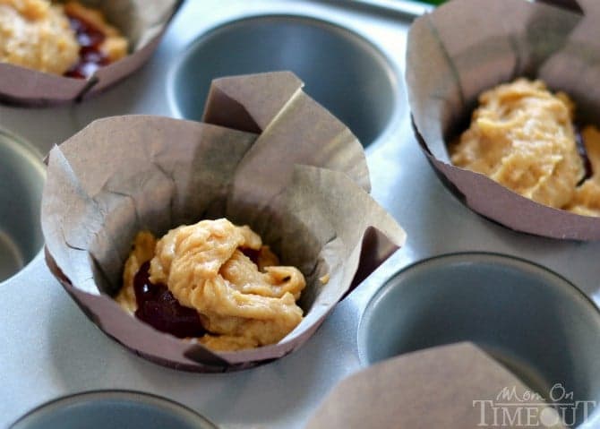 These amazing Peanut Butter and Jelly Muffins make for a delicious and satisfying breakfast on-the-go or a great after-school snack! | MomOnTimeout.com | #recipe #breakfast #snack #peanutbutter