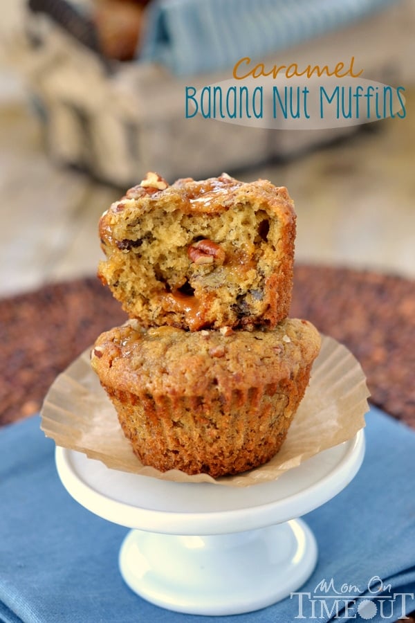 two muffins sitting on small cupcake stand with top muffin torn in half 