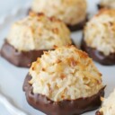 coconut macaroons dipped in chocolate on white cake stand