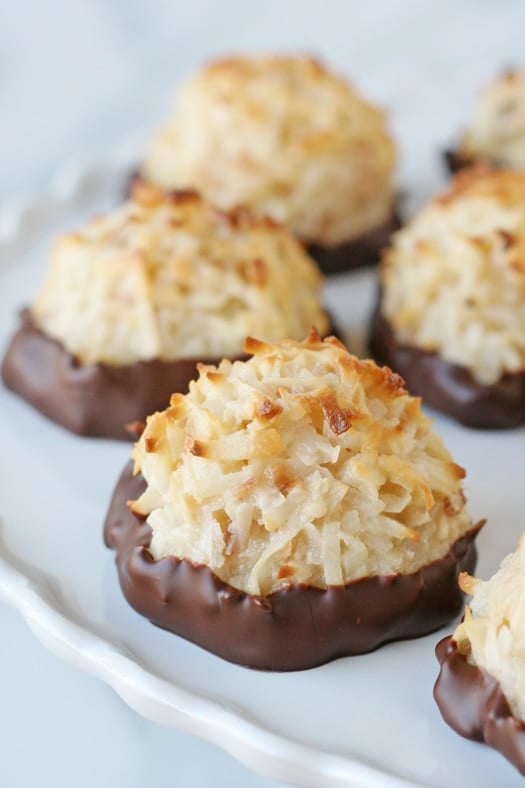 coconut macaroons dipped in chocolate on white cake stand