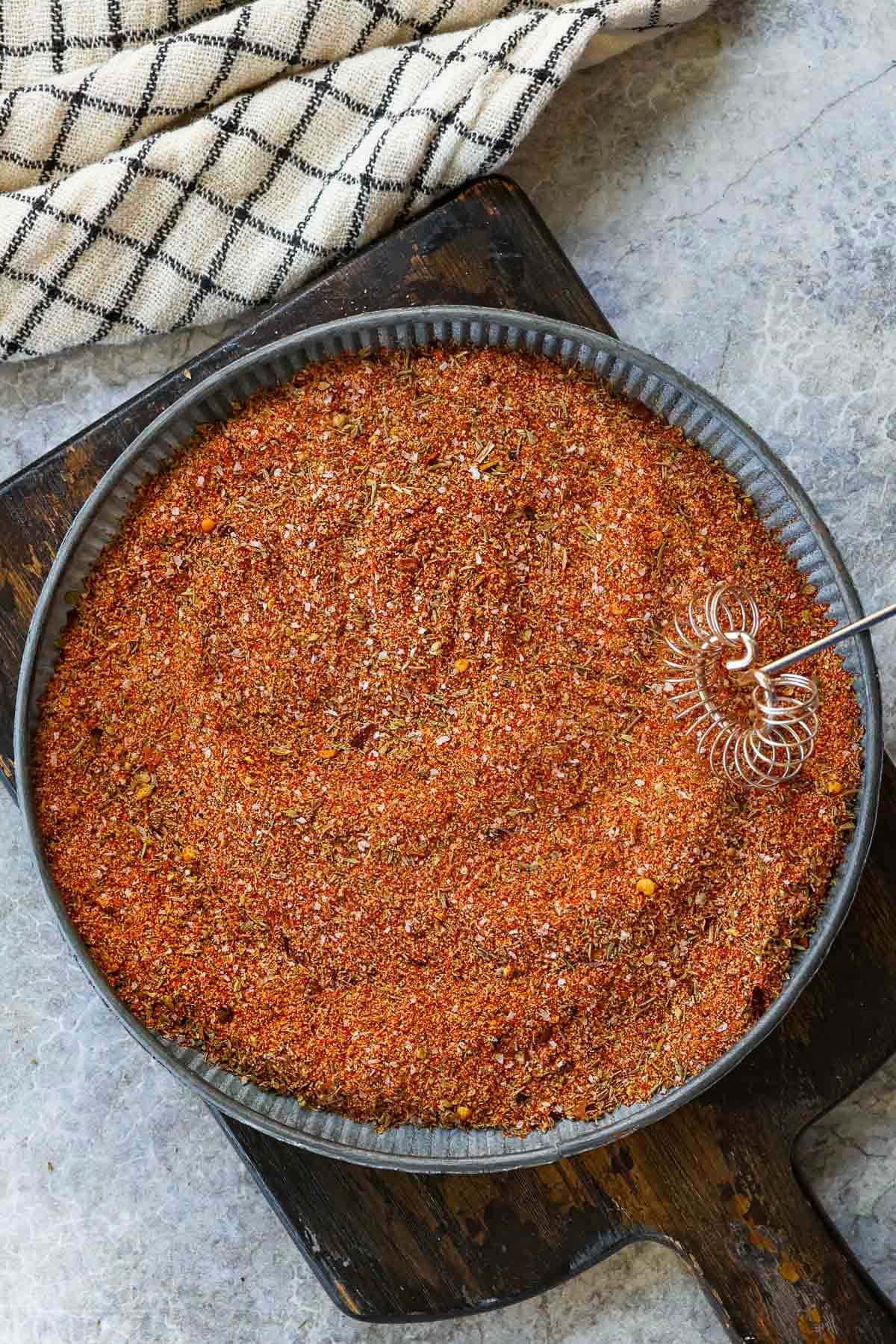 top down view of cajun seasoning mixed in a shallow metal plate ready to be stored for future use.