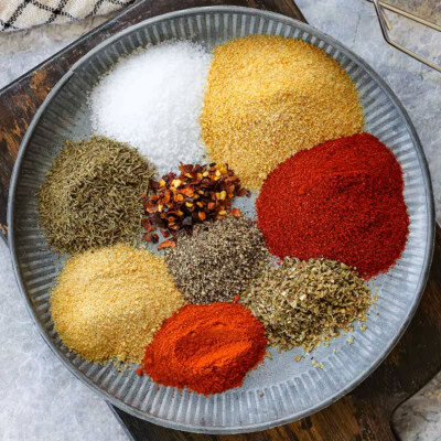 top down look at each of the spices need for cajun seasoning recipe on a shallow plate ready to be combined.