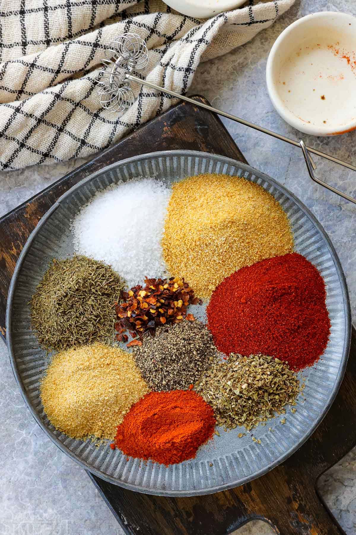 top down look at each of the spices need for cajun seasoning recipe on a shallow plate ready to be combined.