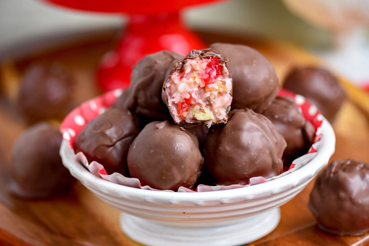 white bowl full of martha washington candy with top candy broken in half. red cake stand can be seen in the background.