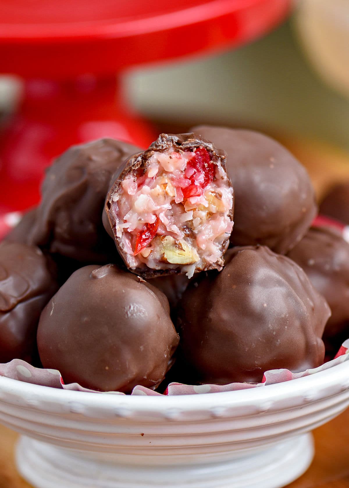 white bowl full of martha washington candy with top candy broken in half. red cake stand can be seen in the background.