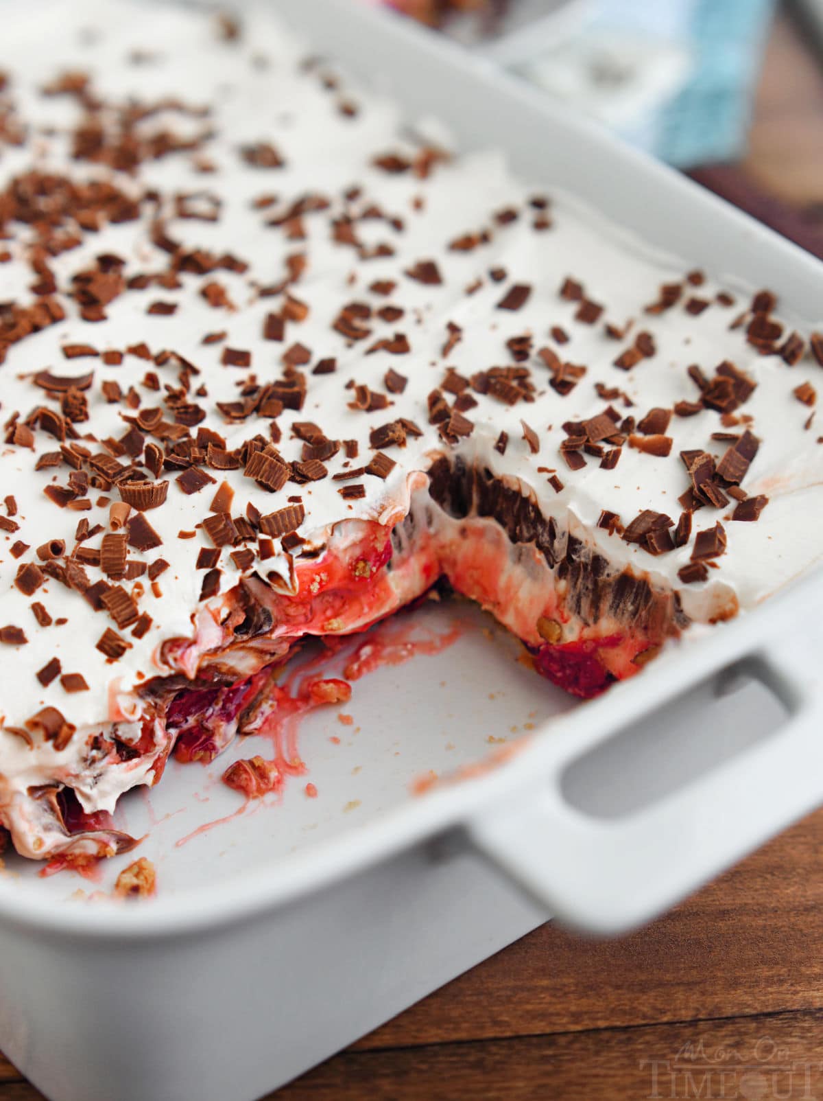 chocolate cherry layered dessert in a white baking dish with two servings removed.