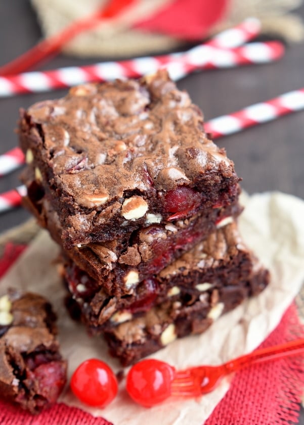 cherry brownies stacked 4 high on brown parchment