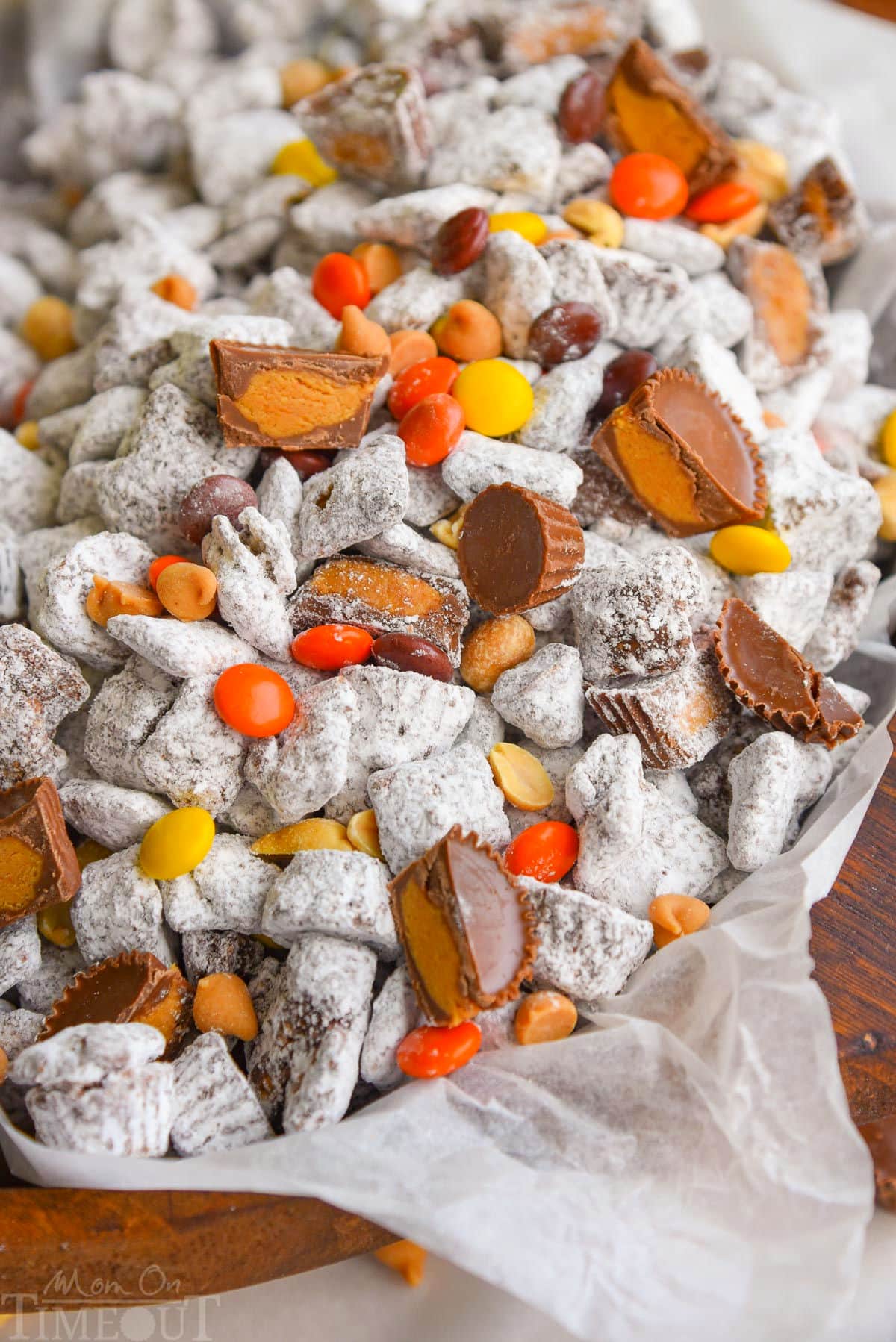 Overhead shot of wood bowl filled with muddy buddies and reeses candy.