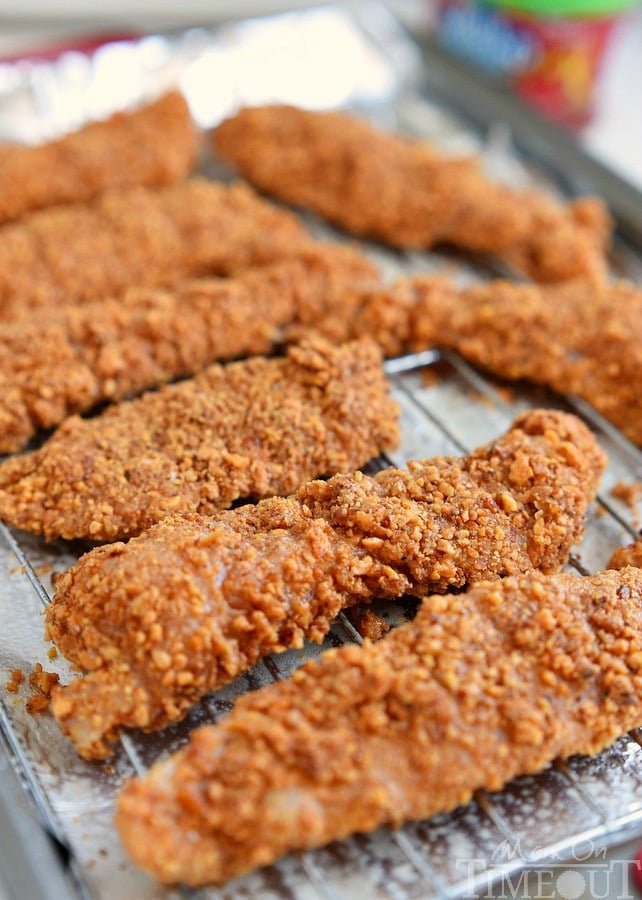 chicken strips coated and rested on metal rack