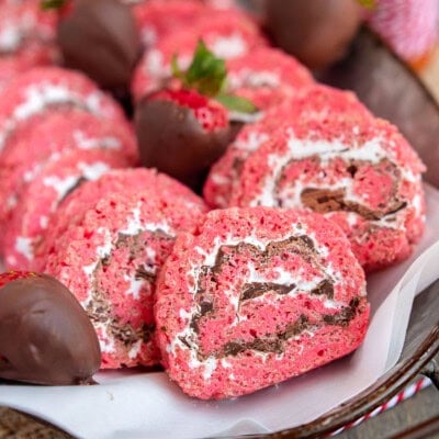 Metal tray filled with strawberry and chocolate rice krispie treat pinwheels along with chocolate covered strawberries.