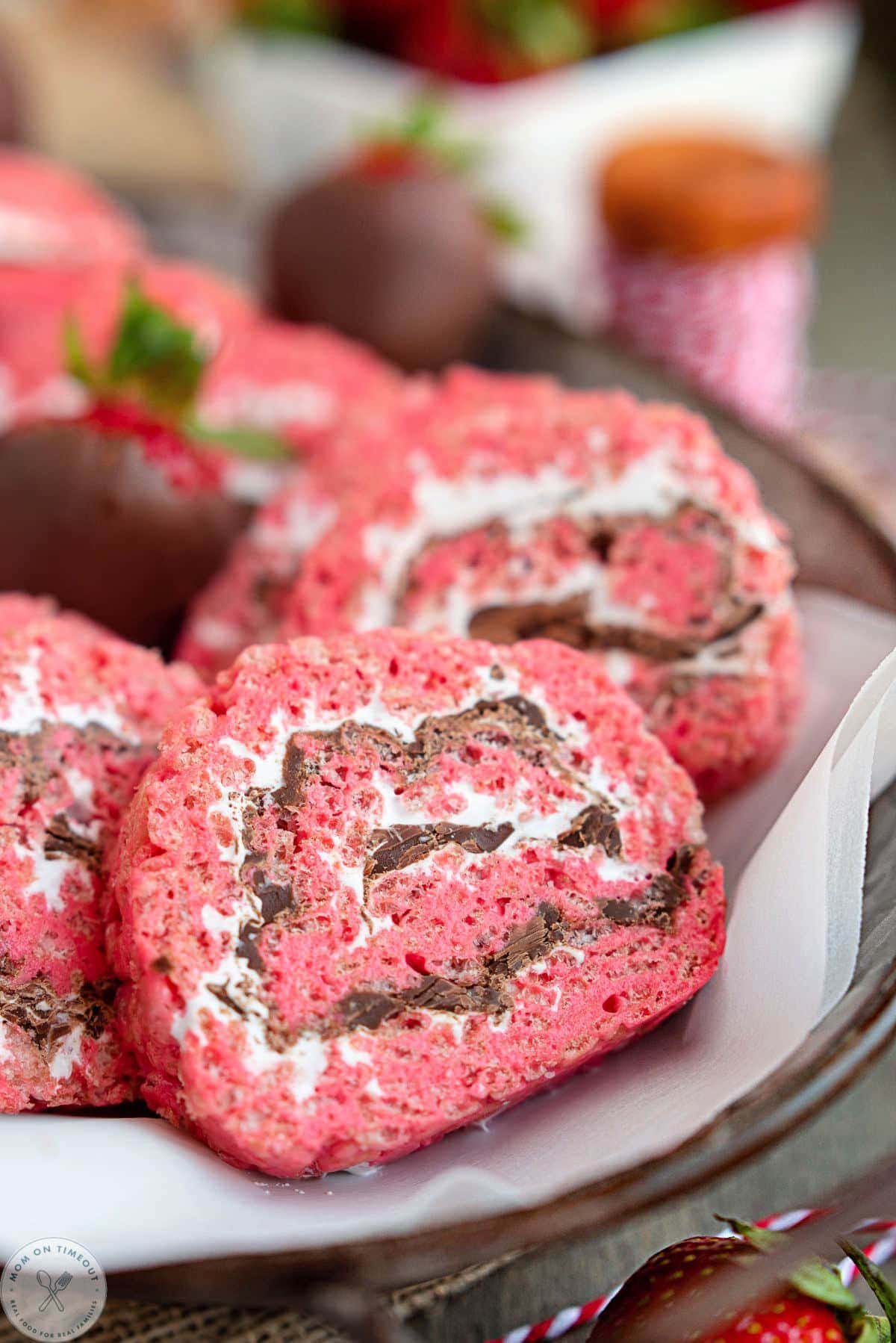 Close up shot of strawberry smores rice krispie treat pinwheels showing the colorful swirls of marshmallow, chocolate and strawberry treats.