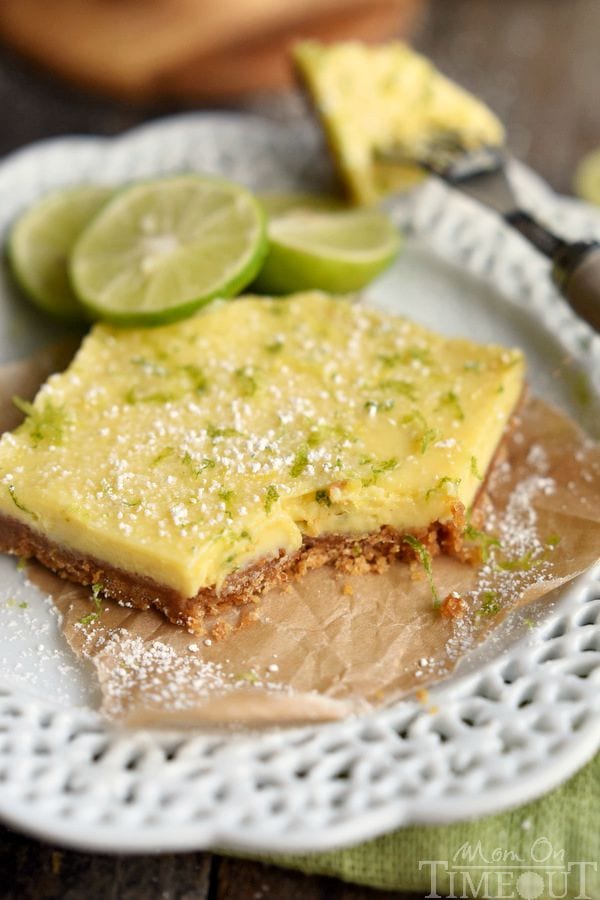 key lime bars with powdered sugar and zest on a white plate