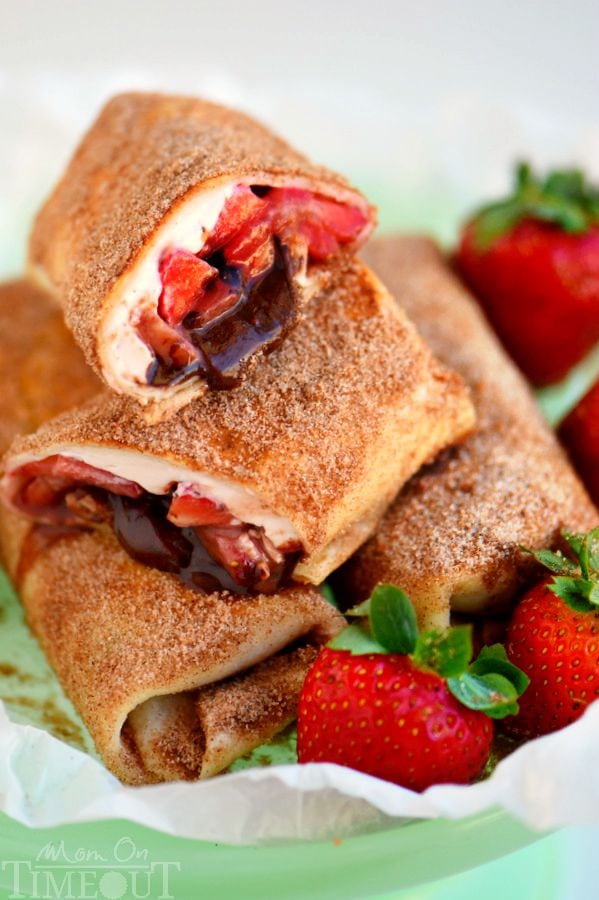 These Chocolate Strawberry Cheesecake Chimichangas are so easy to make and are perfect for a crowd OR an easy weeknight dessert. Fresh strawberries, strawberry cream cheese and chocolate are wrapped in a tortilla, fried to a golden brown and rolled in cinnamon and sugar - totally irresistible! | MomOnTimeout.com