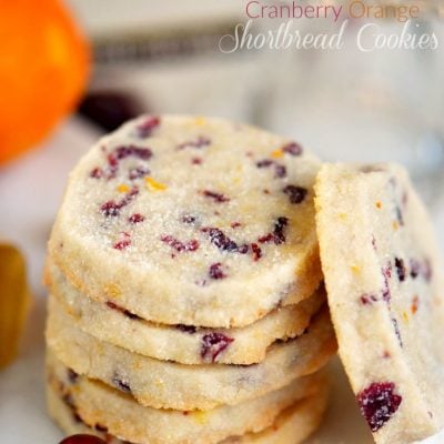 shortbread cookies stacked on white plate with one cookie leaning against the stack