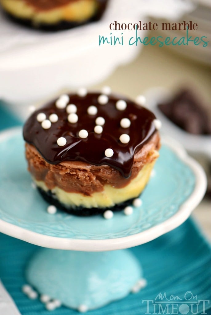 These easy Chocolate Marble Mini Cheesecakes are the perfect treat to make for a crowd! Creamy and decadent, these cheesecakes start with a chocolate crust, creamy chocolate marble cheesecake filling, and are topped with decadent chocolate ganache. // Mom On Timeout #minicheesecakes #cheesecake #chocolate #dessert #mini #momontimeout #recipe #Recipes #desserts #easy mini cheesecake recipe with topping on cupcake pedestal