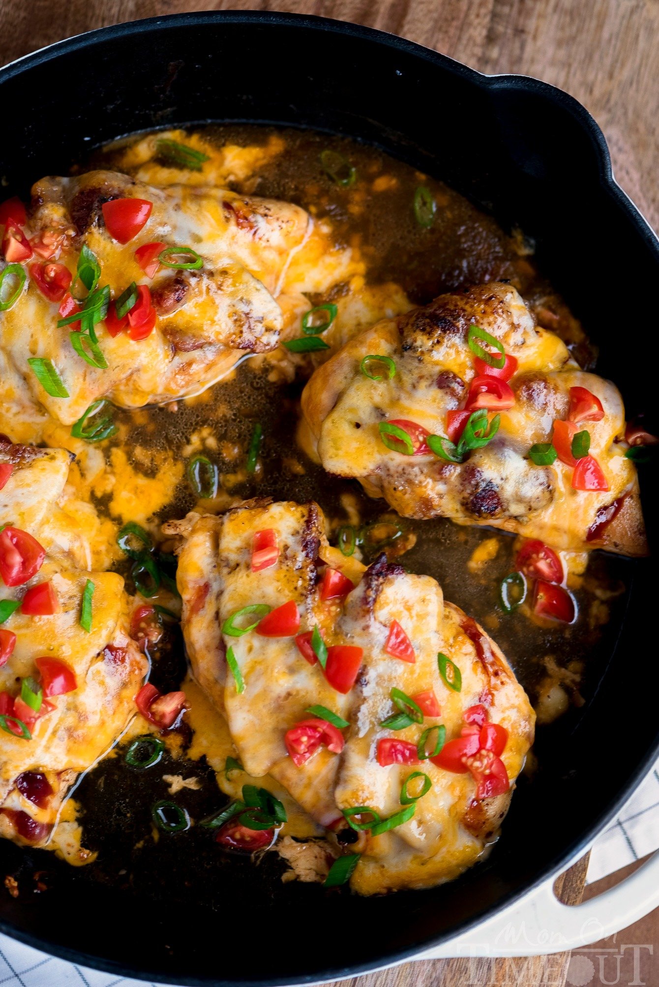 Got 20 minutes? This easy Skillet Monterey Chicken is just what you want to make for dinner tonight...trust me! Chicken, barbecue sauce, bacon, and glorious cheese come together in this delightful yet simple dish. Sure to become a regular request at your home! // Mom On Timeout #montereychicken #chickendinner #skilletdinner #easyrecipe #chicken #bacon #cheese #skillet #recipe monterey chicken top down view in skillet with broth