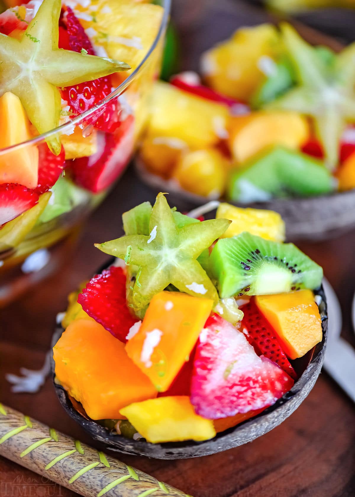 coconut half filled with tropical fruit salad. very brightly colored fruits.