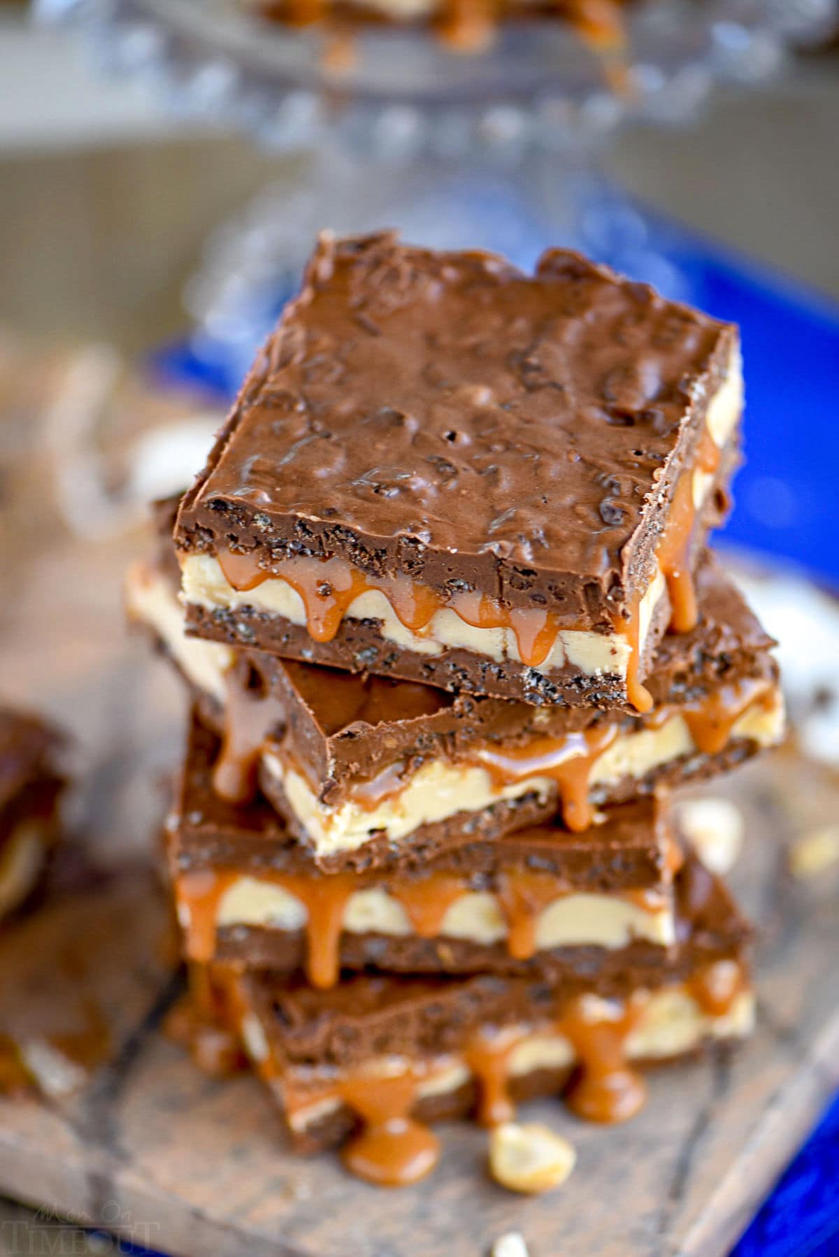 top down look at a stack of crispy snickers bars with caramel dripping out of the sides.