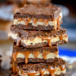 caramel nougat snickers bars stacked on each other, four high.