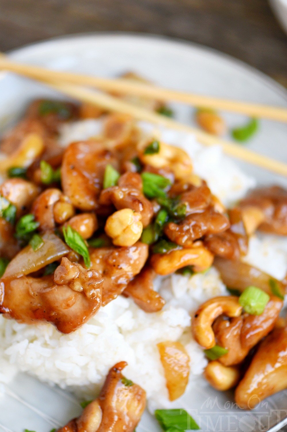 Love quick and easy dinner recipes? This one is for you! This Easy Cashew Chicken takes less than 30 minutes to make and is way better than takeout! Add it to your menu this week! // Mom On Timeout #cashewchicken #chickenrecipe #chickenrecipes #chicken #chinese #dinner #easydinner #takeout easy cashew chicken recipe with sauce on plate with chopsticks