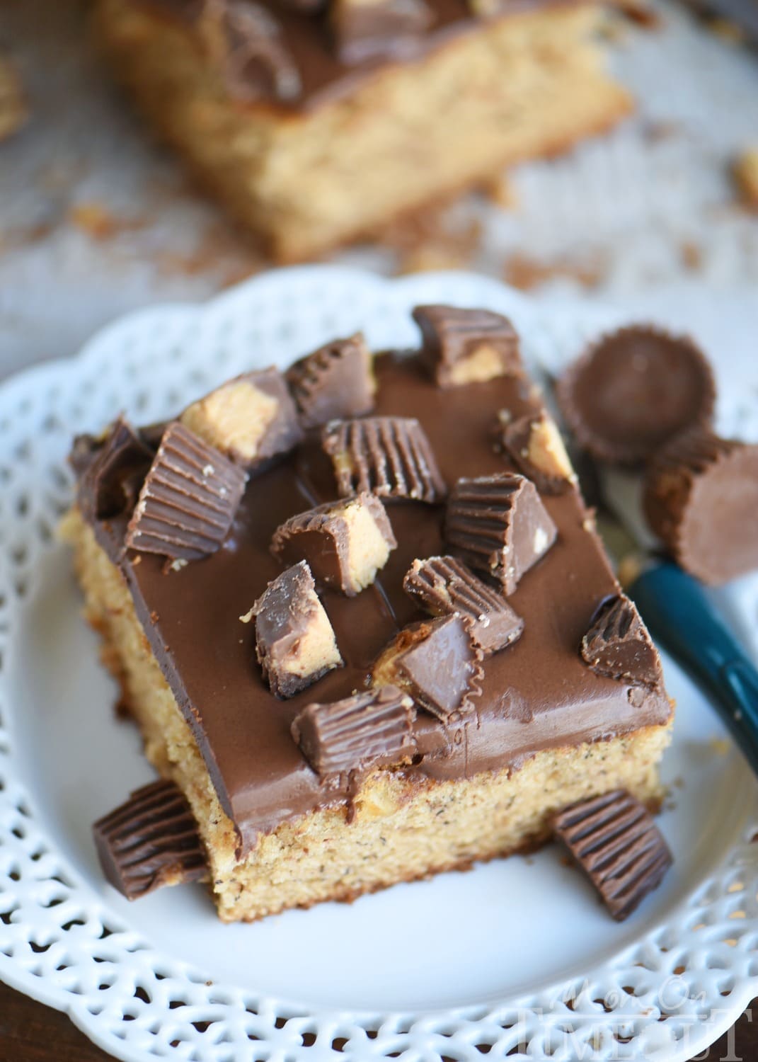 This easy Peanut Butter Banana Cake is topped with a peanut butter chocolate glaze and Reese's candy! An easy dessert that feeds a crowd! Great for parties and peanut butter lovers! // Mom On Timeout